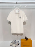 A polo shirt with embroidered letters on the eyes of a golden little monster on the chest
