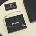 Black gold iridescent enamel bow necklace