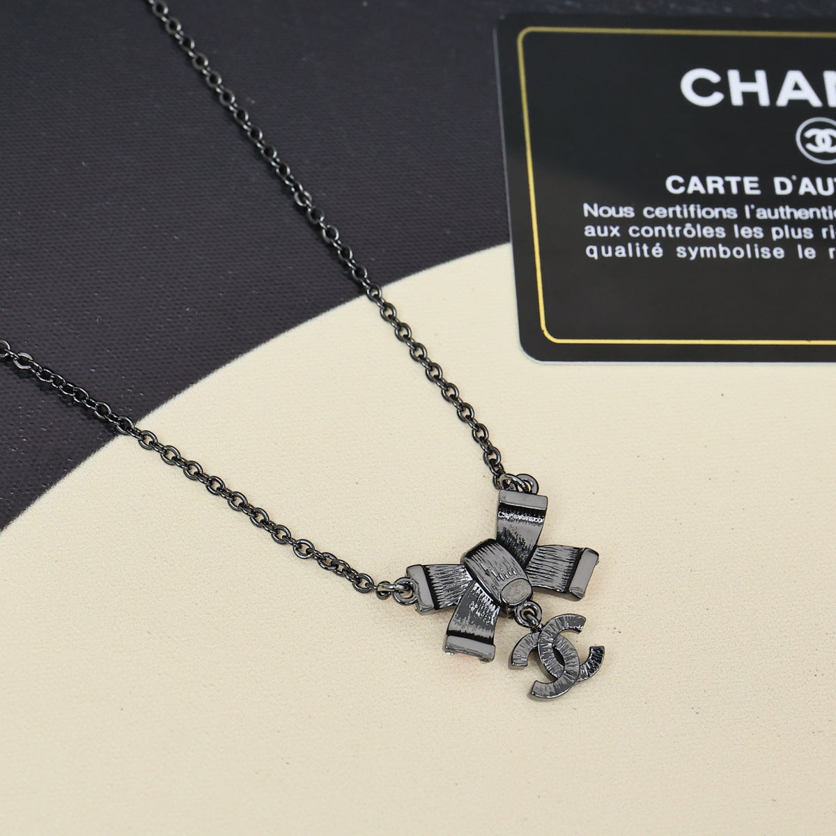Black gold iridescent enamel bow necklace