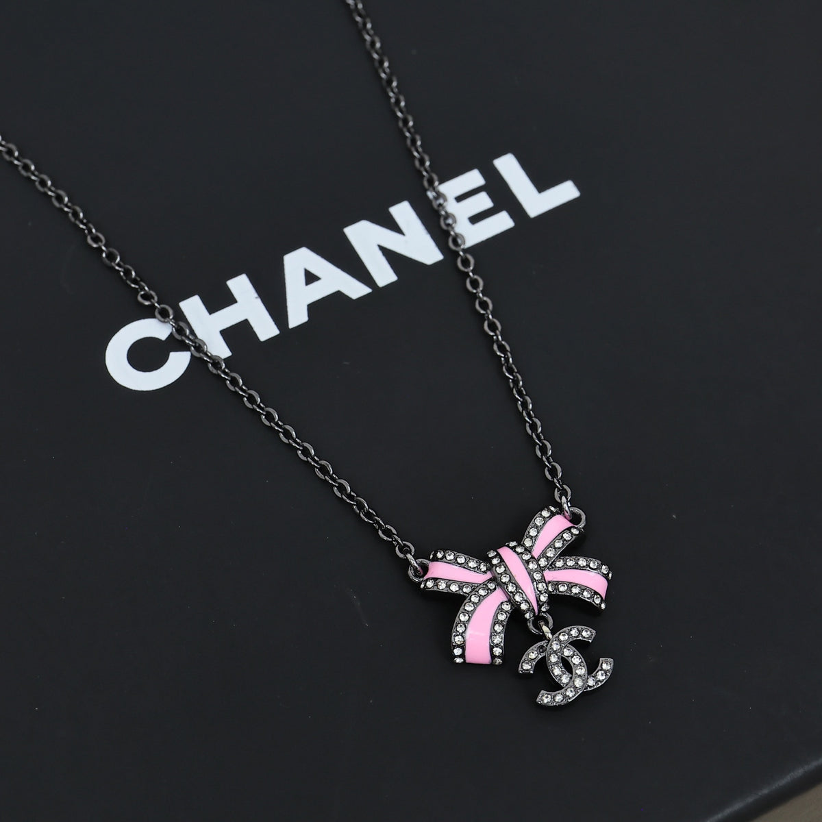 Black gold iridescent enamel bow necklace