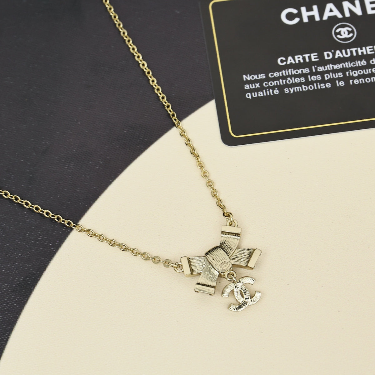 Black gold iridescent enamel bow necklace