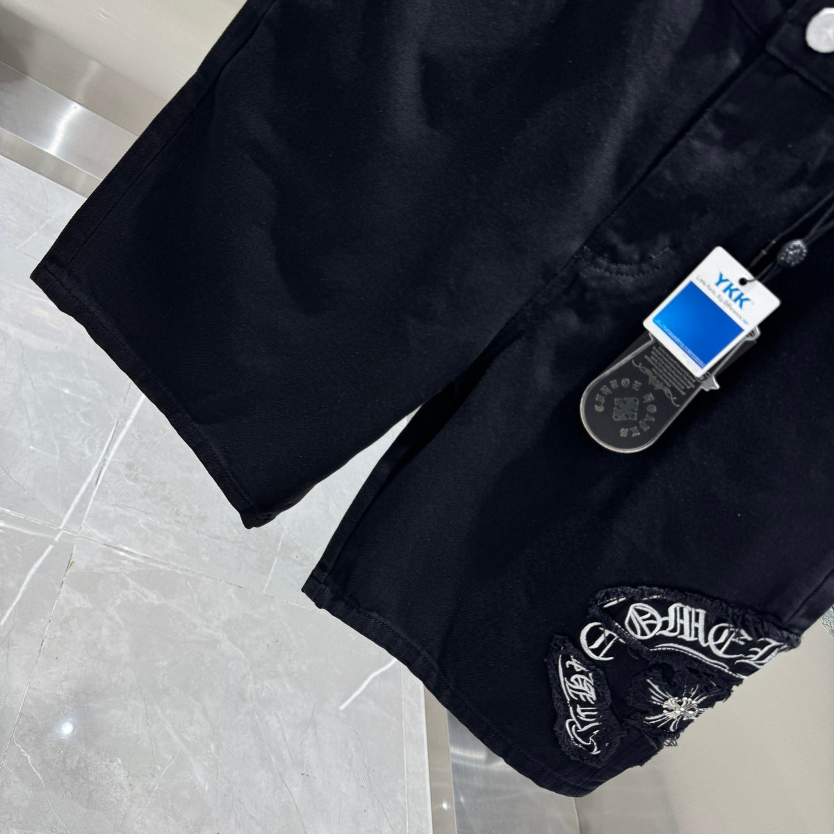 Embroidered cross denim shorts with torn holes