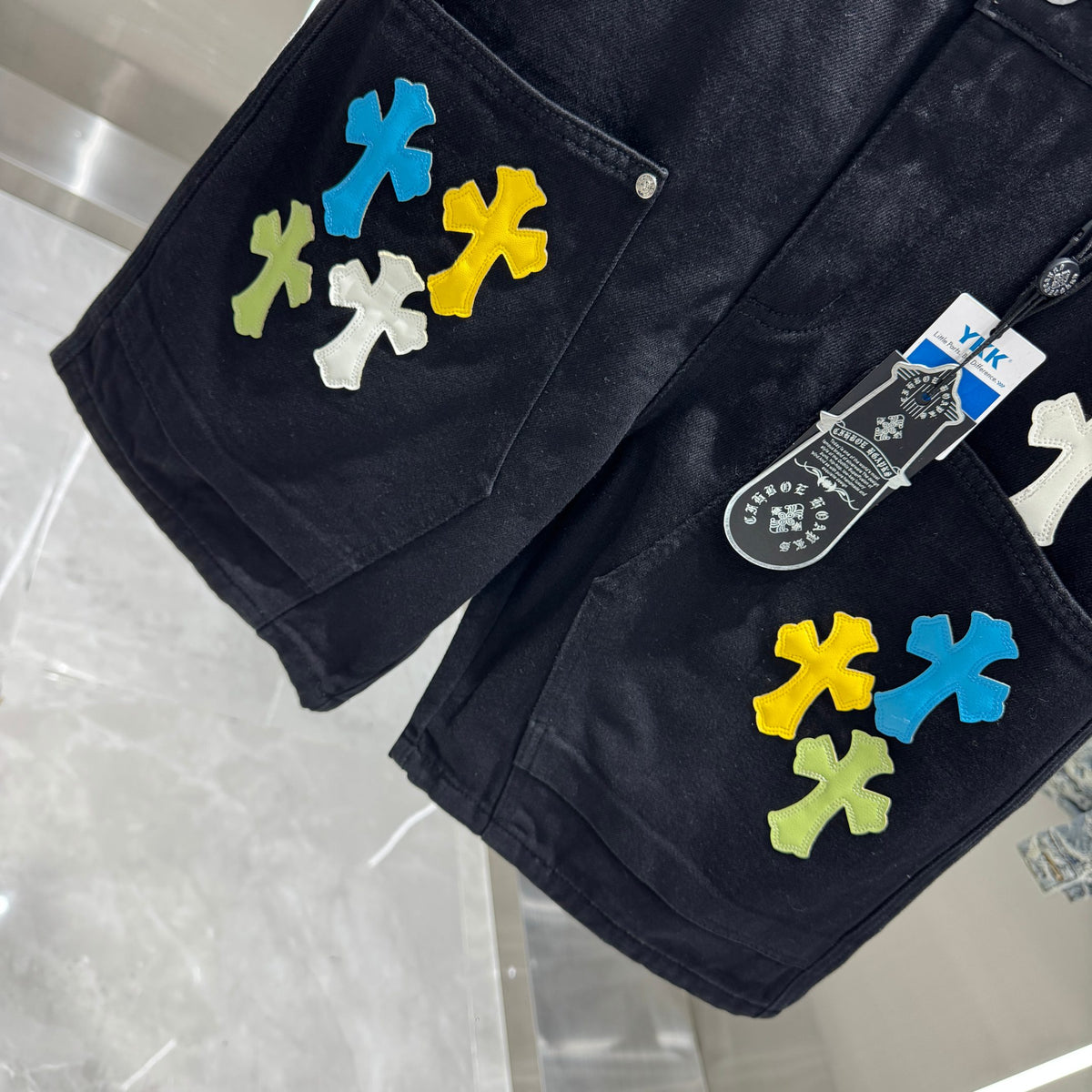 Embroidered cross denim shorts with torn holes