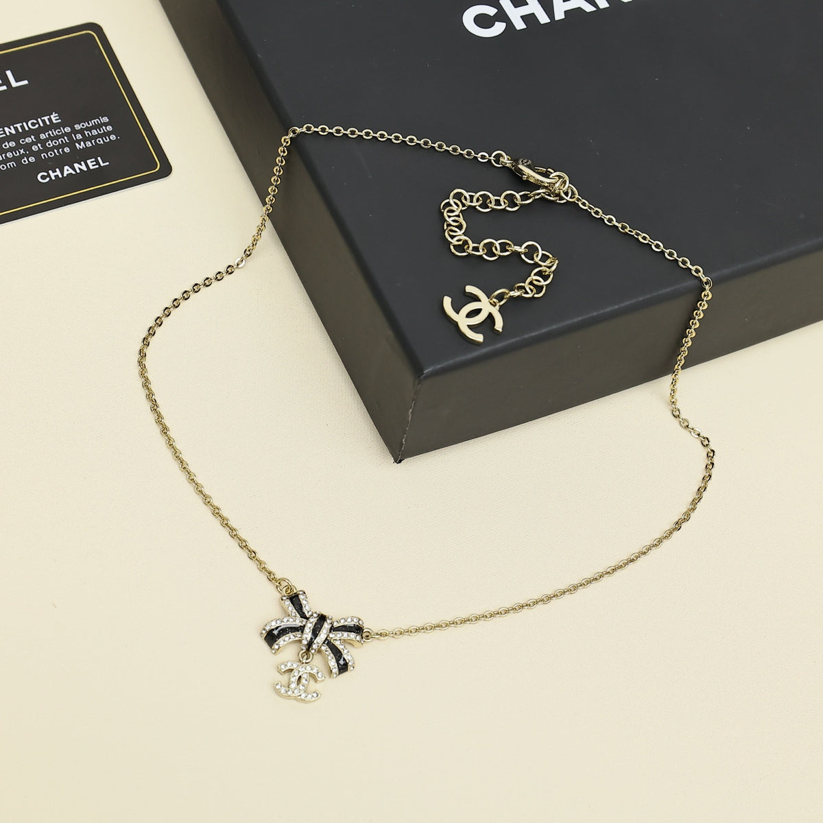 Black gold iridescent enamel bow necklace